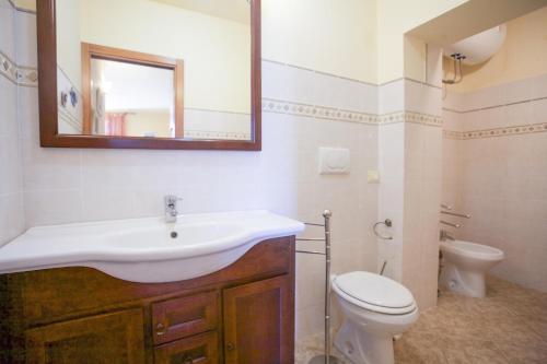 a bathroom with a sink and a toilet and a mirror at Appartamento Il Golfo in Portoferraio