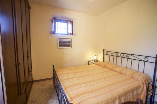 1 dormitorio con cama y ventana en Appartamento Il Golfo, en Portoferraio