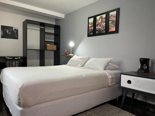 una camera da letto con un grande letto bianco e un tavolo di Sambleña a Cuzco