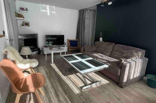a living room with a couch and a table at Appartement jardin à 20 minutes de Paris centre in Le Pecq
