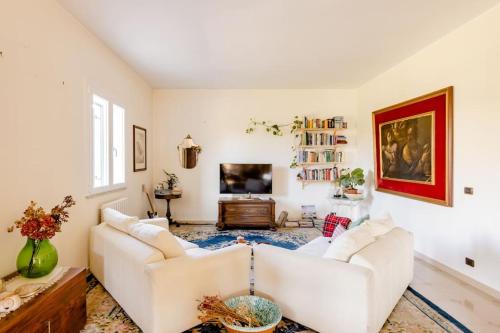 ein Wohnzimmer mit 2 weißen Sofas und einem TV in der Unterkunft Villa La Serenata di Pietro in Taranto