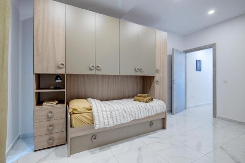 1 dormitorio con 1 cama y armario de madera en Modern Family Holiday Retreat in Gzira, en Sliema