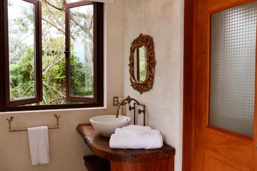 a bathroom with a bowl sink and two windows at Hotel La Semilla a Member of Design Hotels in Playa del Carmen