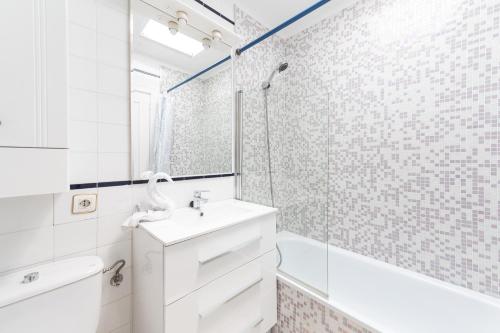 a white bathroom with a sink and a shower at La casa de Montse Vivienda Vacacional Playa de la Tejita in El Médano