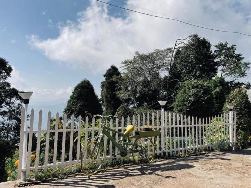 a bike parked next to a white fence at K - Den Homestay in Kurseong