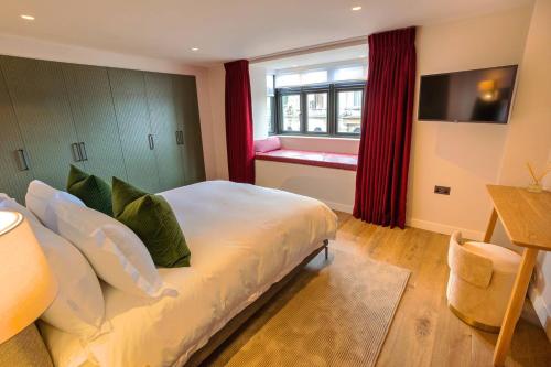 a bedroom with a bed and a window with a red curtain at The Royal Suite- Harbour Views- Ramsgate in Kent