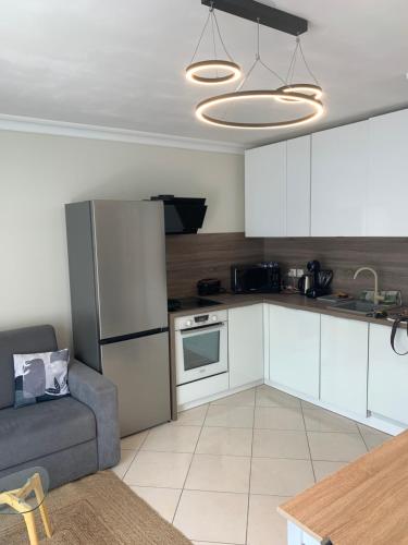 Il comprend une cuisine équipée d'un réfrigérateur et un canapé. dans l'établissement Bord de mer Juan les Pins, à Antibes