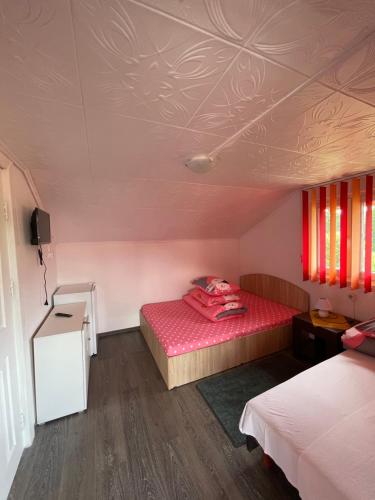 Cette petite chambre dispose de deux lits et d'un plafond. dans l'établissement Pensiunea Maria, à Sovata