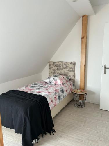 a bedroom with a bed with a black blanket at GITE MA MAISON in Kintzheim