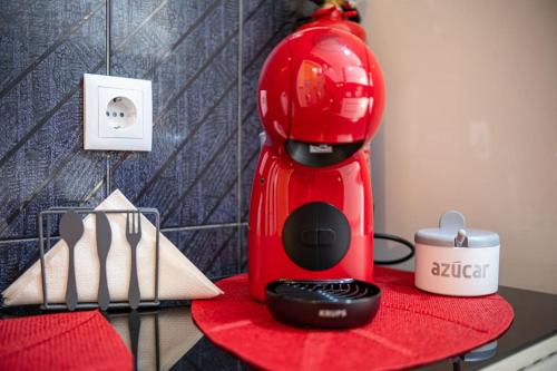 a red blender sitting on top of a table at Milena's House in Nazaré