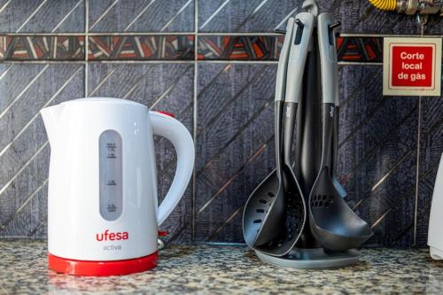 a coffee mug and utensils on a counter at Milena's House in Nazaré