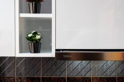 a cabinet with a microwave and flowers in it at Milena's House in Nazaré