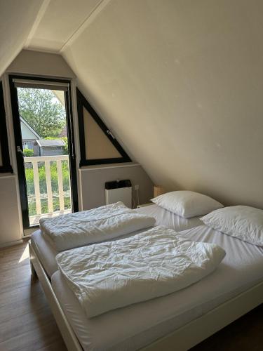 Ένα ή περισσότερα κρεβάτια σε δωμάτιο στο vakantiehuis Lieke Lauwersmeer met sauna