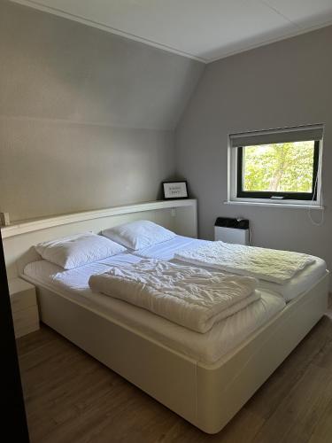 Ένα ή περισσότερα κρεβάτια σε δωμάτιο στο vakantiehuis Lieke Lauwersmeer met sauna
