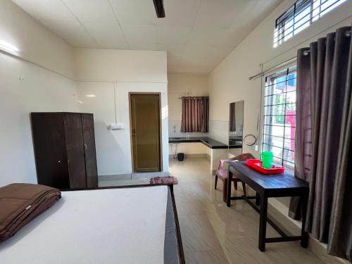 a room with a bed and a table in it at Atithya Lodge in Guwahati