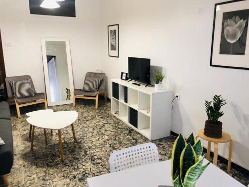 a living room with a tv and a table and chairs at Apartament con Encanto in Castellón de la Plana