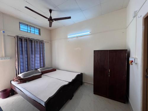 a bedroom with a bed and a wooden cabinet at Atithya Lodge in Guwahati
