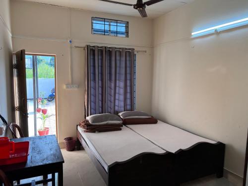 a bedroom with a bed in a room with a window at Atithya Lodge in Guwahati