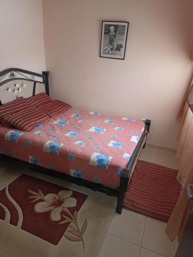 a bedroom with a bed and a rug at Le bon séjour in Ifrane