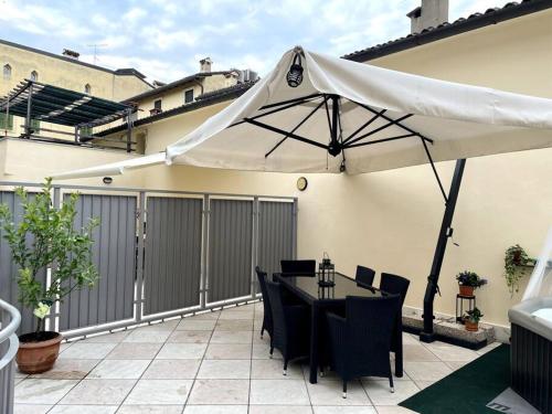 ヴェローナにあるL'appartamento di Giuliettaのパティオ(テーブル、白い傘付)