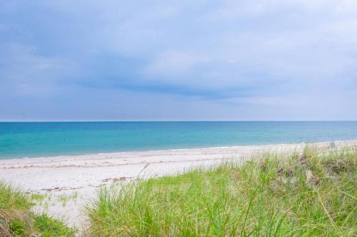 a sandy beach with the ocean in the background at Sand, Sun Serenity: Cape Cod Escape in East Sandwich