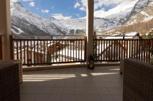 a balcony with a view of snow covered mountains at Victoria's Home - luxurious penthouse in Saas-Fee
