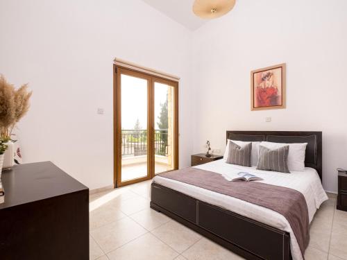 a bedroom with a large bed and a window at Almond Grove Luxury Villa Wprivate Pool in Simou