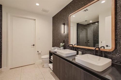 a bathroom with two sinks and a mirror at 2BD Condo-Rainey St-Best views-RT Pool in Austin