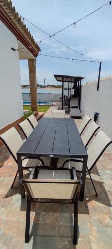 uma mesa preta e cadeiras num pátio em Chalet Hercules la barrosa em Chiclana de la Frontera