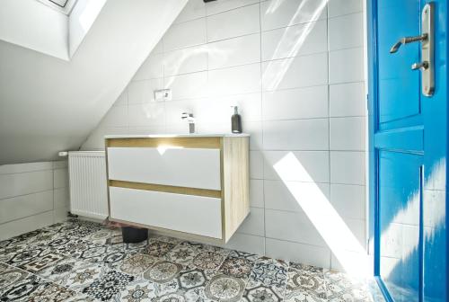 uma casa de banho com um lavatório e uma porta azul em Vila Ochutnej Pálavu - apartmán Riesling em Pavlov