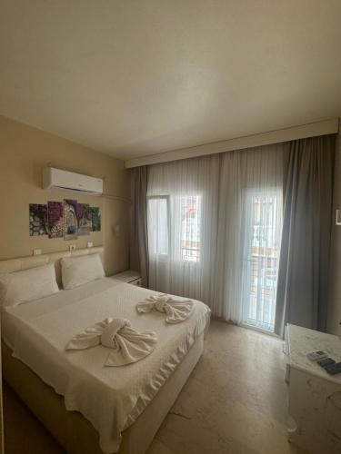 um quarto com uma cama com duas toalhas em Koz Eren Otel Çeşme em Cesme