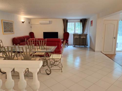 a living room with a red couch and a table at Location Rez de maison dans quartier charmant in Saint-Raphaël