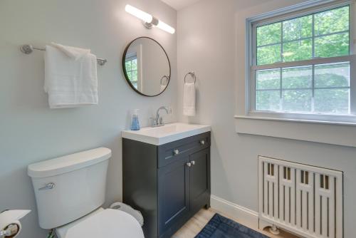 een badkamer met een toilet, een wastafel en een spiegel bij Cozy New Hampshire Retreat with Deck and Fire Pit! in North Conway