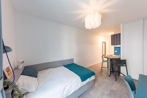 a small bedroom with a bed and a table at Cute Studio close to Paris - 1P - 501 in Ivry-sur-Seine