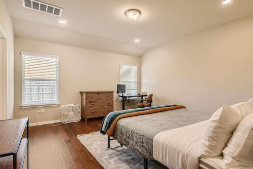 a bedroom with a bed and a desk and windows at Serene 3BR Retreat near East Austin in Austin