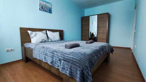 a bedroom with a large bed with blue walls at Запорізька 19. City Rooms in Bila Tserkva