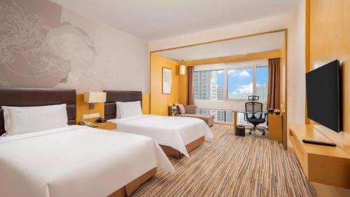 a hotel room with two beds and a flat screen tv at Holiday Inn Shijiazhuang Central by IHG in Shijiazhuang