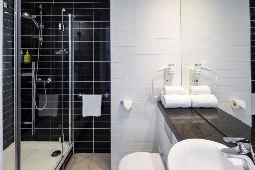 een badkamer met een douche, een wastafel en een toilet bij Holiday Inn Express Amsterdam - Sloterdijk Station, an IHG Hotel in Amsterdam