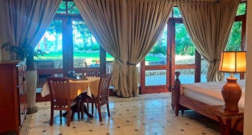 a bedroom with a bed and a table and chairs at El Guayacán in Valle la Laguna