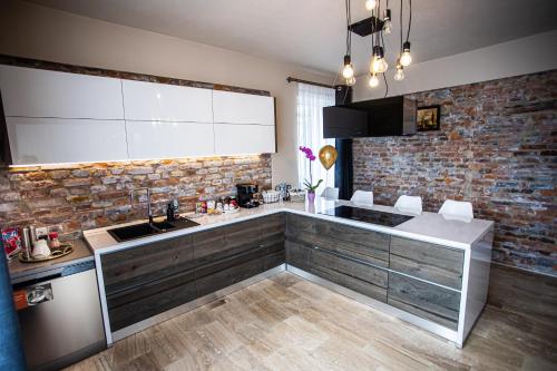 a kitchen with a sink and a brick wall at Casa Armoniei in Baia Mare