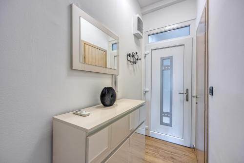 un pasillo con un tocador y un espejo junto a una puerta en Sara Luxury in City Center, en Poreč