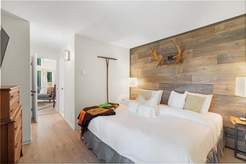 1 dormitorio con 1 cama grande y cabecero de madera en Le Champetre Tremblant 2bdrs Condo W Fireplace en Mont-Tremblant