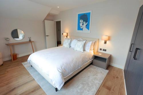 a bedroom with a large white bed and a mirror at SoHot Stays The Penthouse Suite - Harbour Views - Sleeps 4 in Kent