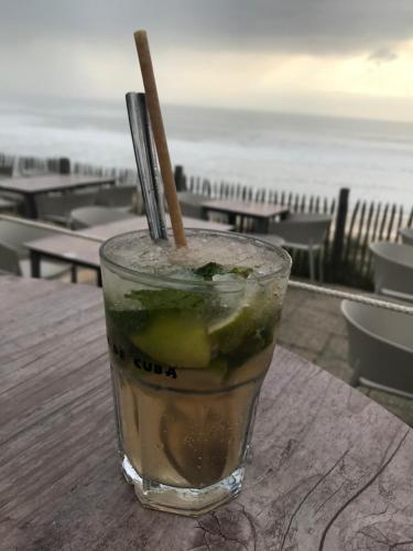 - une boisson assise sur une table avec vue sur l'océan dans l'établissement Cosy T2 front de mer piscine parking terrasse, à Lacanau-Océan