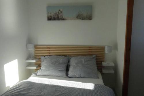un lit avec une tête de lit en bois dans une chambre dans l'établissement Hossegor Appartement T2 cabine - Superbe Vue Océan, à Soorts-Hossegor