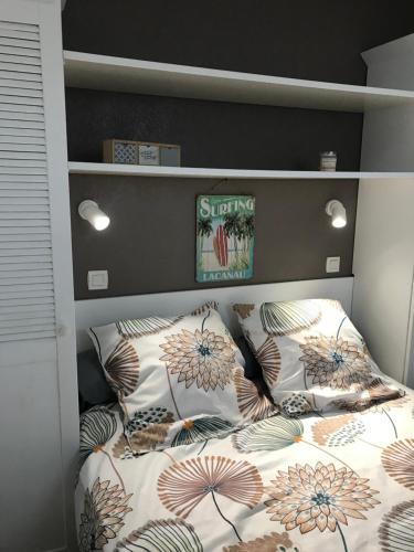un lit avec des oreillers dessus dans une chambre dans l'établissement Cosy T2 front de mer piscine parking terrasse, à Lacanau-Océan
