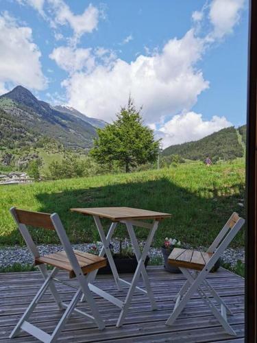 a picnic table and two chairs on a wooden deck at Appartement Termignon Val Cenis in Termignon