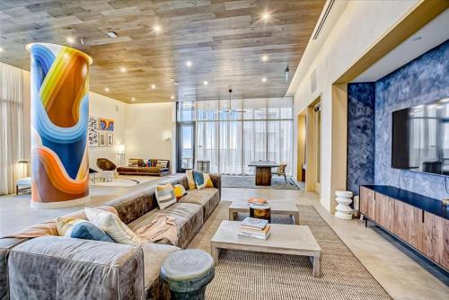 a living room with a couch and a tv at Brand New Rainey Street Condo with City and Lake View in Austin