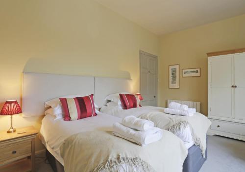 a bedroom with two beds with towels on them at Wing Cottage in Orford