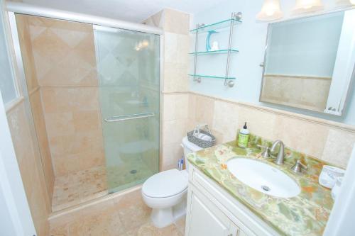 een badkamer met een douche, een wastafel en een toilet bij Sea Coast Gardens II 401 in New Smyrna Beach